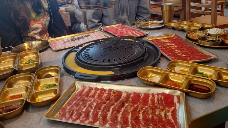 Los ingredientes se disponen alrededor de la parrilla para que cada comensal pueda cocinarlo a su gusto