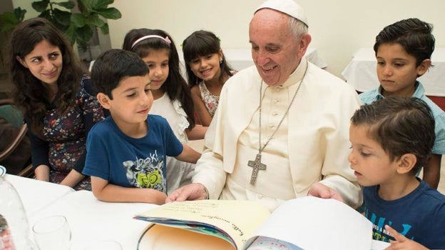 El Papa Francisco lee un cuento a unos niños sirios acogidos refugiados en Lesbos y acogidos en su residencia de Santa Marta en el Vaticano
